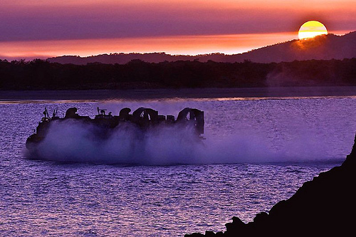 Landing Craft, Air Cushion (LCAC) 10, assigned to Assault Craft Unit (ACU) 5, makes a late-afternoon run to the beach while transporting U.S. Marines and vehicles back to the amphibious assault ship USS Essex (LHD 2). Essex is participating in Talisman Saber 09, a biennial, combined exercise designed to train Australian and U.S. forces in planning and conducting combined operations.  (U.S. Navy photo by MC2 Gabriel S. Weber/Released)